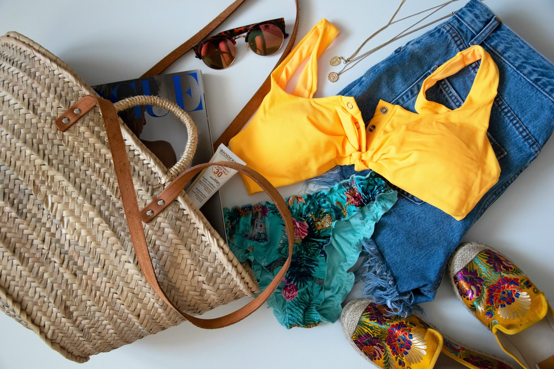 Summer flat lay with mineral sunscreen, sunglasses, and beach essentials