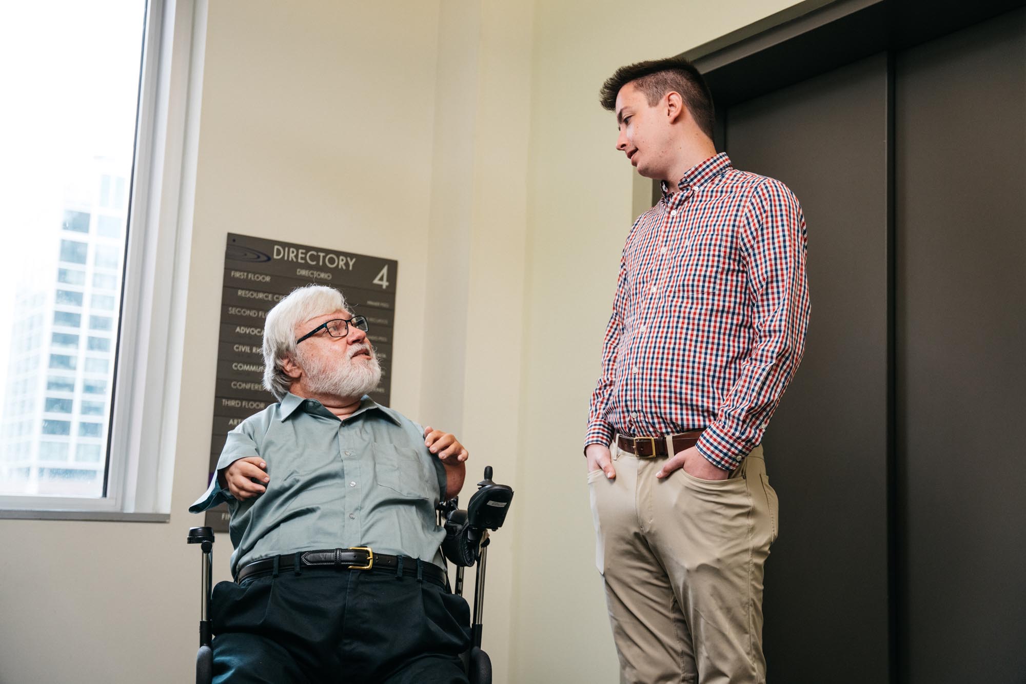 Two coworkers talking in office hallway